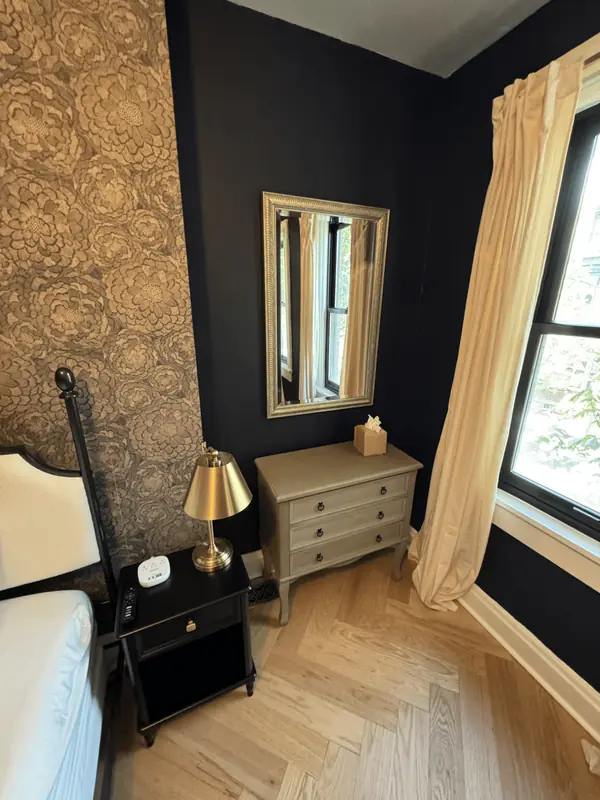Tidy corner with a nightstand, brass lamp, dresser and mirror