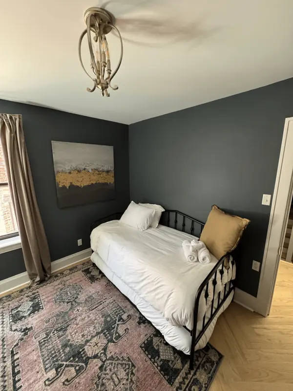 Guest room with a daybed, white bedding and rolled towels